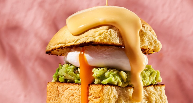 Eggs benedict op brioche met geprakte avocado